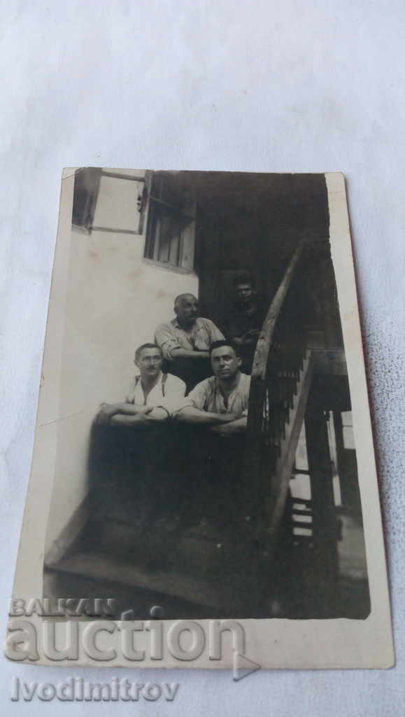 Foto Patru bărbați pe scările de lemn