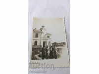 Photo Four men in front of a newly built house with a bell tower