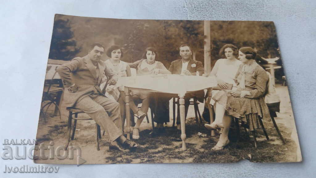 Φωτογραφία Γυναίκες και άνδρες που κάθονται γύρω από ένα τραπέζι 1930