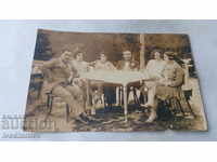 Снимка Жени и мъже седнали около маса 1930