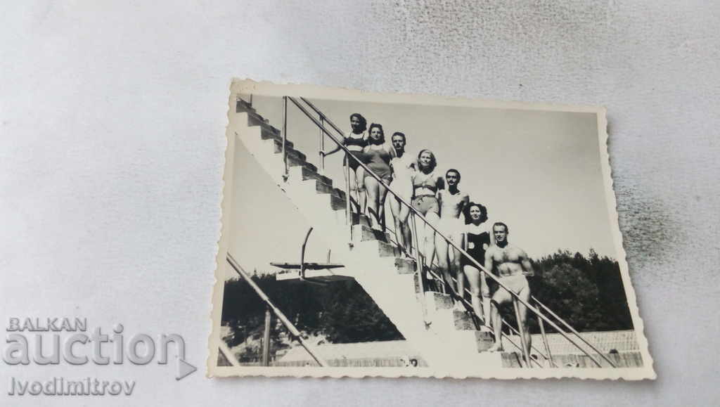 Φωτογραφία Άνδρες και γυναίκες με μαγιό στη σκάλα στην πισίνα