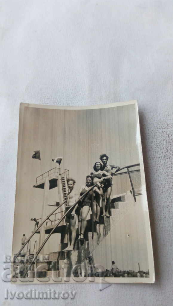 Φωτογραφία Άνδρες και γυναίκες με μαγιό στη σκάλα στην πισίνα