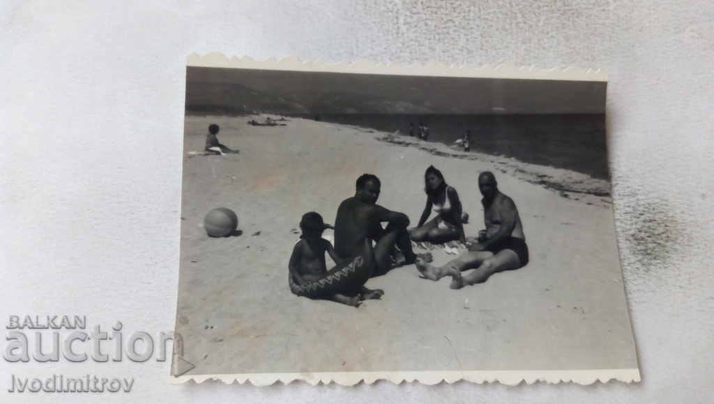 Foto Doi bărbați, o femeie și un copil pe plajă