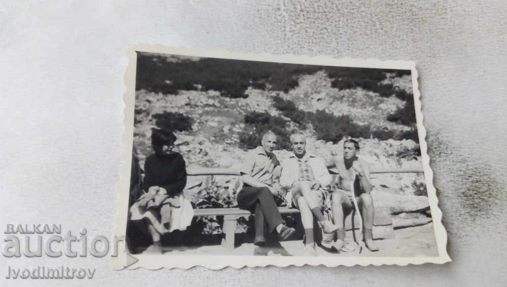 Photo Three men on a bench in the mountains