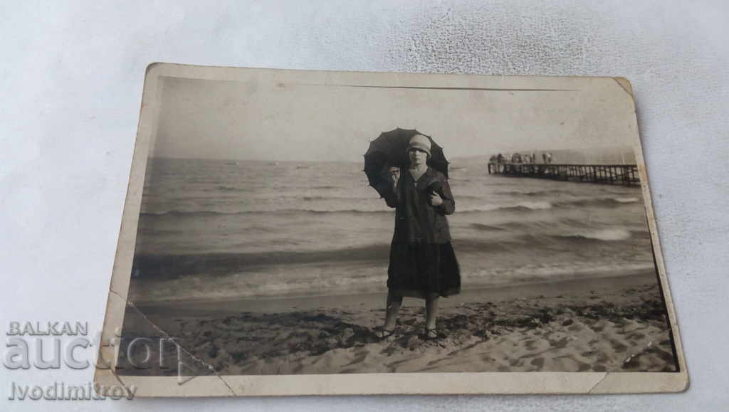 Photo Young girl with a black umbrella on the beach