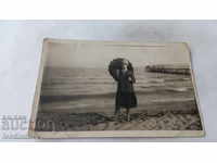 Fotografie Fată tânără cu o umbrelă neagră pe plajă