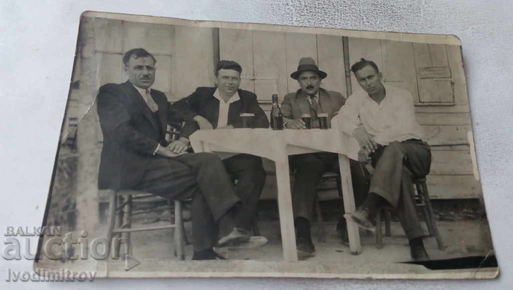 Photo Four men over a glass of wine