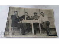Φωτογραφία Τέσσερις άνδρες πάνω από ένα ποτήρι κρασί