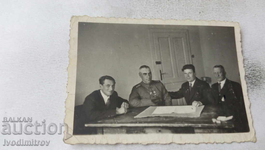 Fotografie Un ofițer cu un ordin și trei oameni la o masă