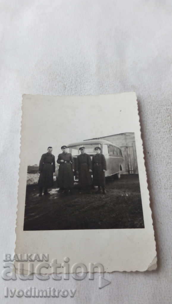 Ofițer foto și trei soldați în fața unui autobuz retro