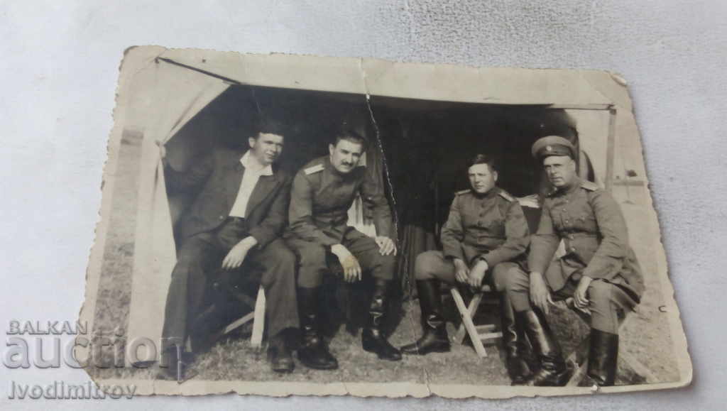 Photo A man and three officers in front of the tent