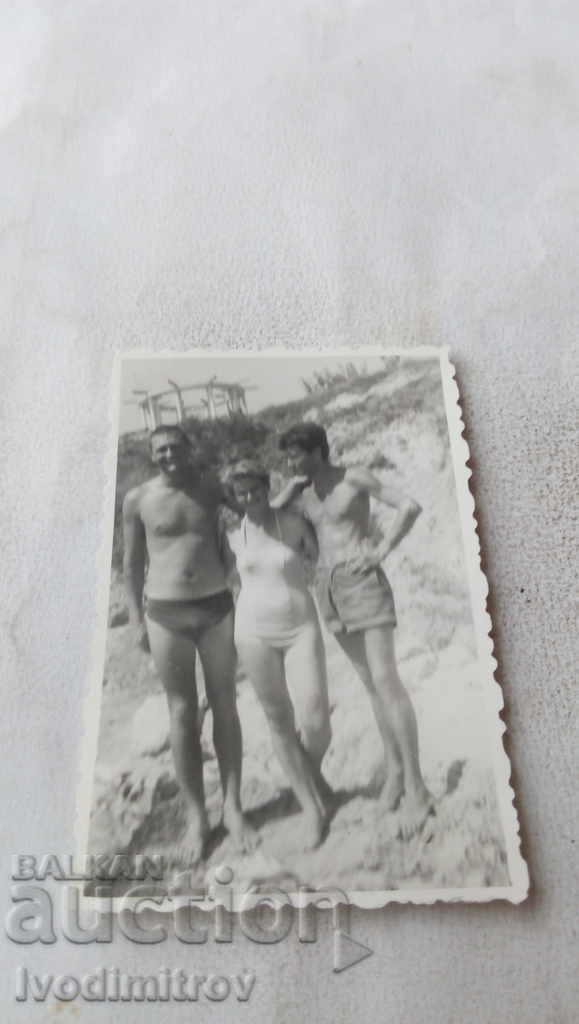 Foto Femeie și doi bărbați pe plajă