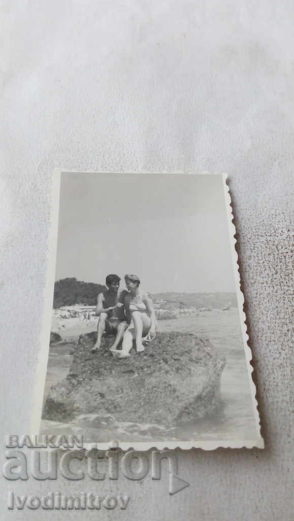 Φωτογραφία Άνδρας και γυναίκα σε έναν βράχο στη θάλασσα