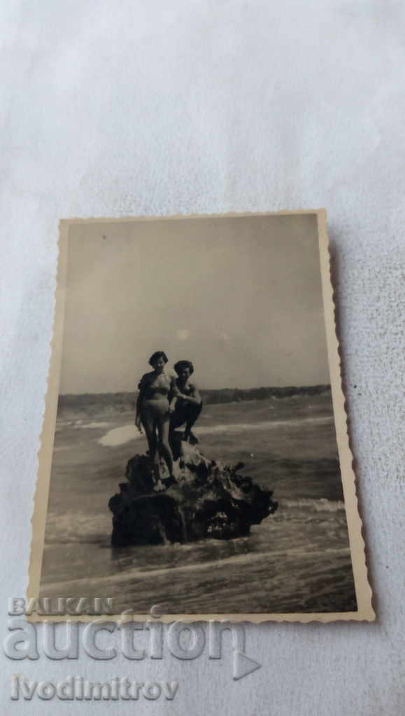 Photo Man and woman on a rock in the sea