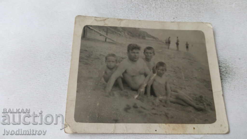 Foto Bărbat și trei copii pe plajă