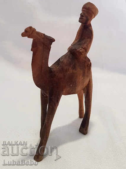 Delivery of Hand-carved wooden figure of a camel with a rider. Delivery of Hand-carved wooden figure of a camel with a rider.