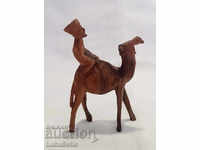 Hand-carved wooden figure of a camel with a rider.