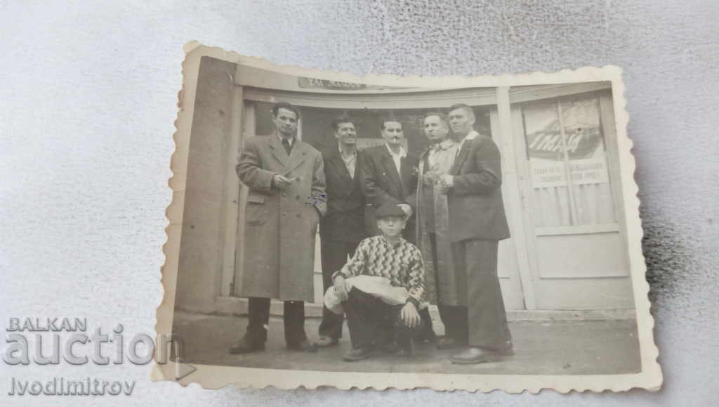 Foto Șase bărbați în fața unui magazin