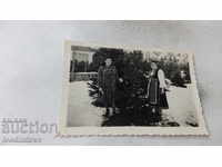 Fotografie Două femei lângă un pin iarna