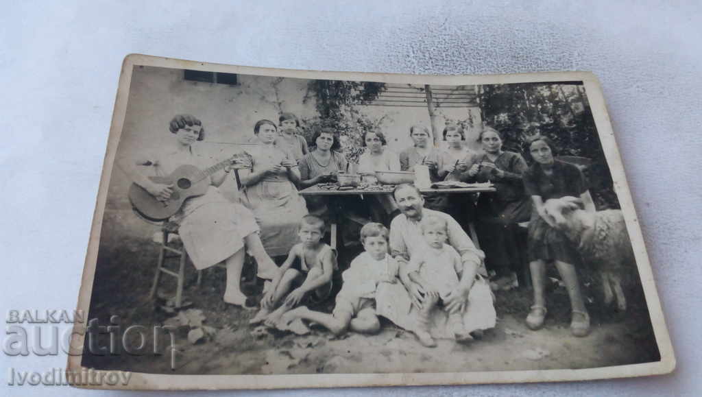 Photo Women and children at a table in the yard of his house