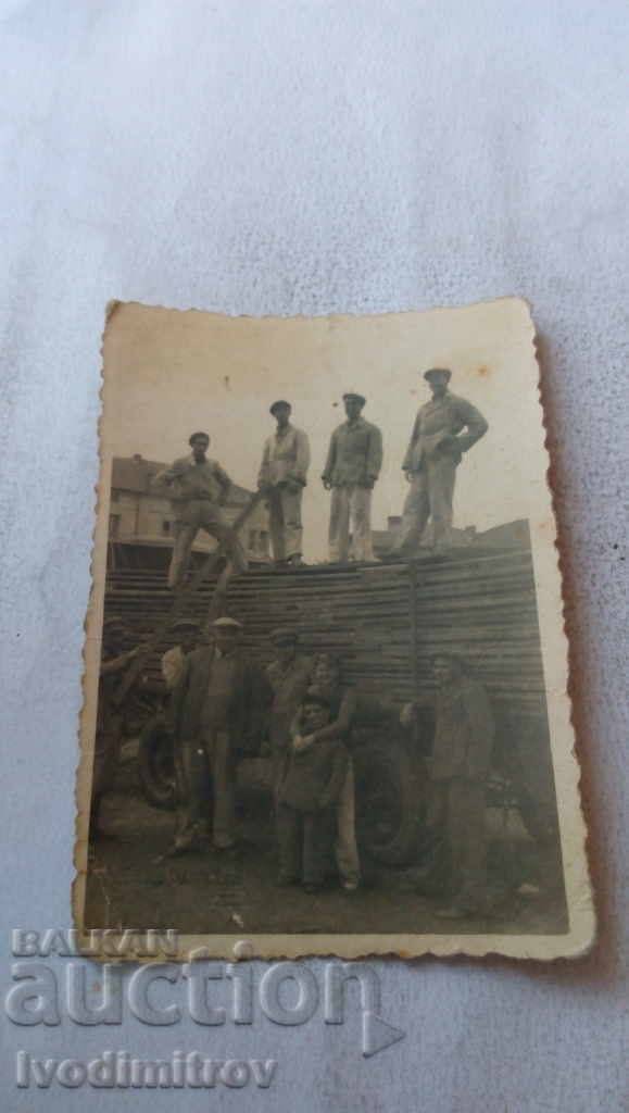 Photo Men unload timber