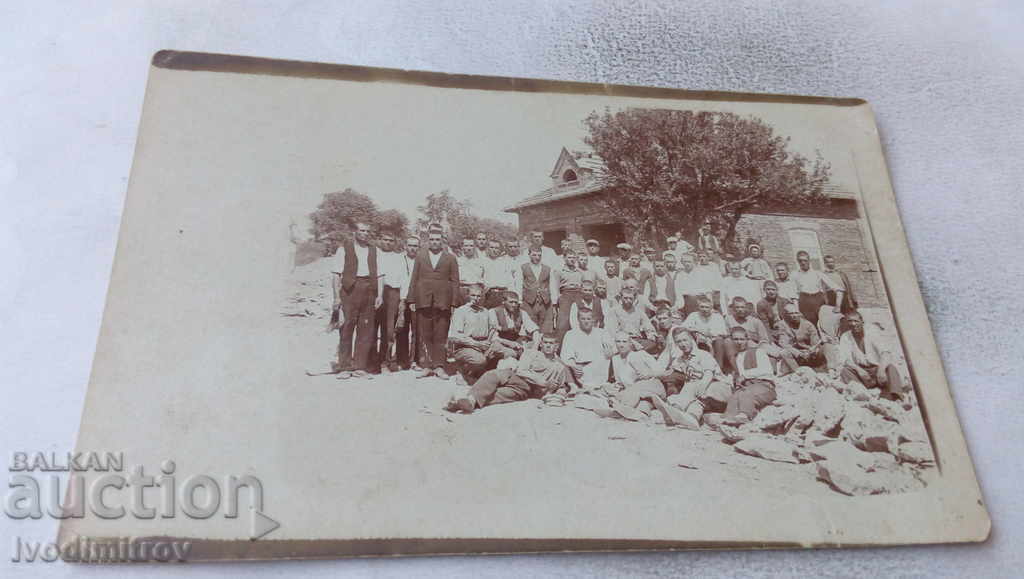 Photo A group of workers in front of a newly built building