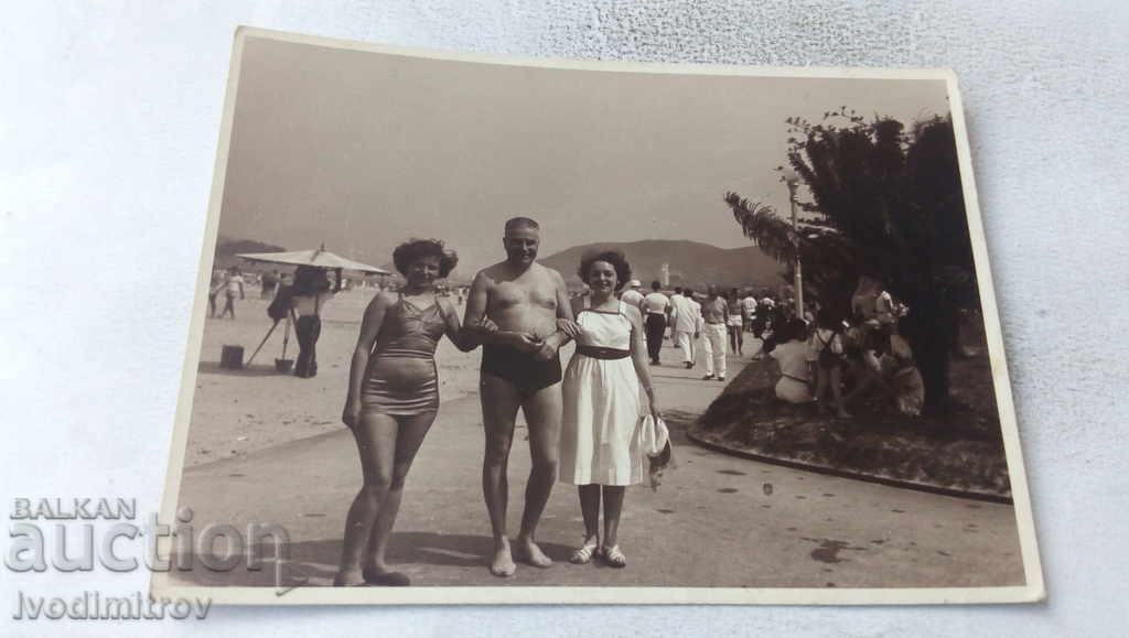 Photo A man and two women on the alley by the beach