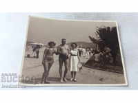 Photo A man and two women on the alley by the beach
