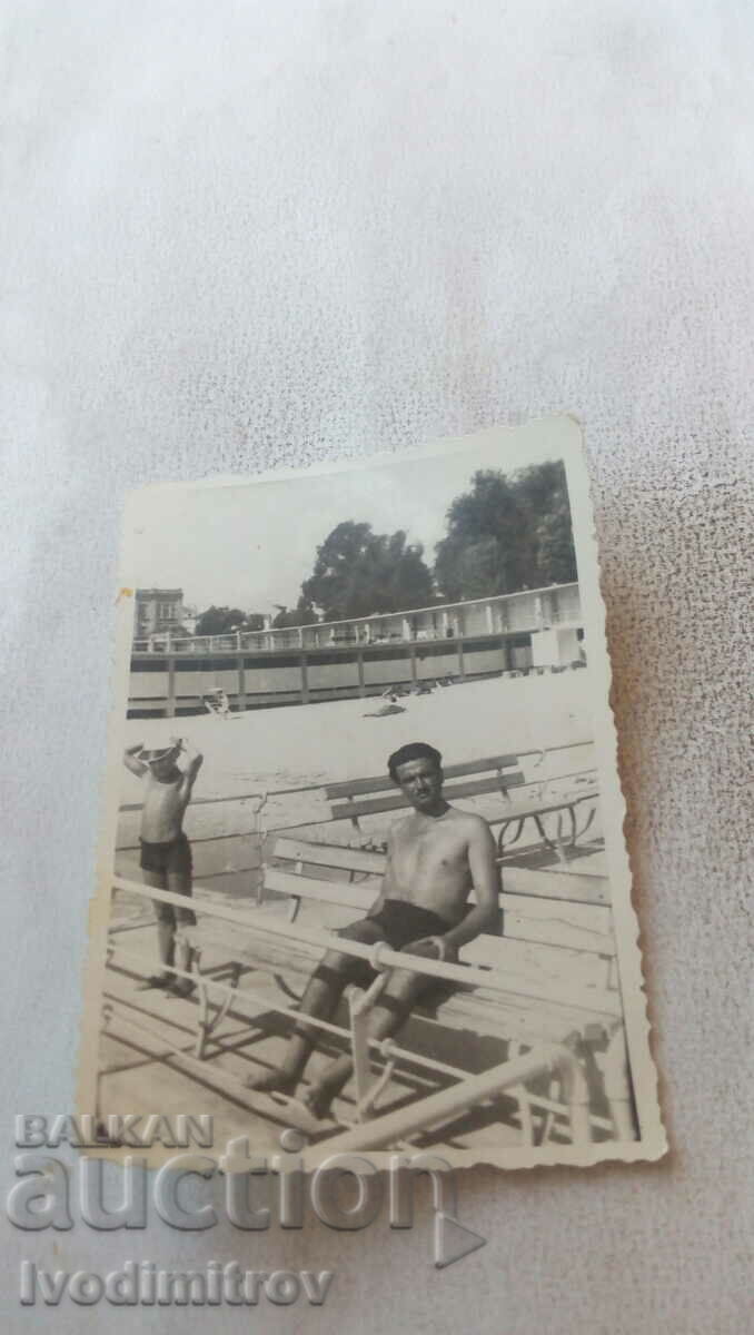 Photo of man in swimsuit on bench