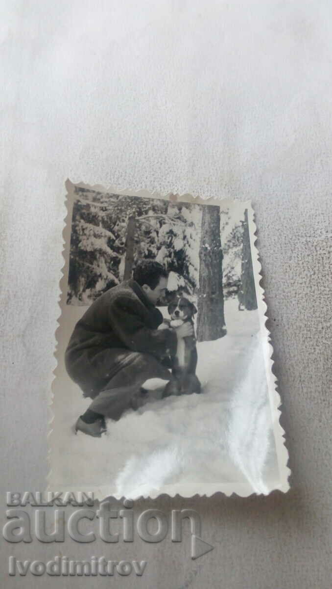 Снимка Мъж с куче в снега