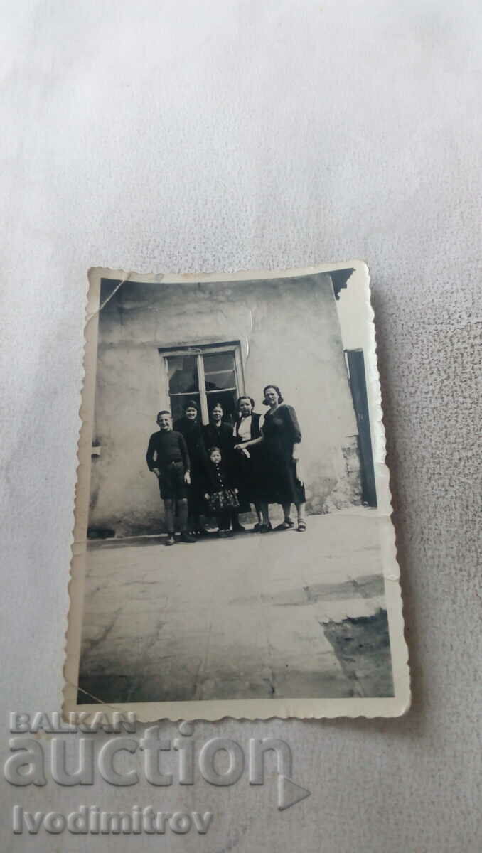Photo Young women and children in front of a house