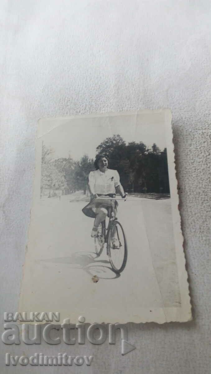 Φωτογραφία Νεαρή γυναίκα με ένα ρετρό ποδήλατο