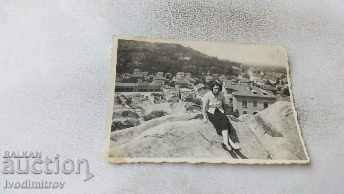 Φωτογραφία Νεαρό κορίτσι στους βράχους πάνω από την πόλη