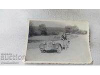 Φωτογραφία Γυναίκα δίπλα σε ένα ρετρό αυτοκίνητο με reg. Ф Sf 1908