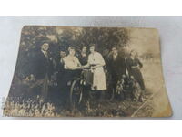 Photo of young men and women and retro bicycle in the park