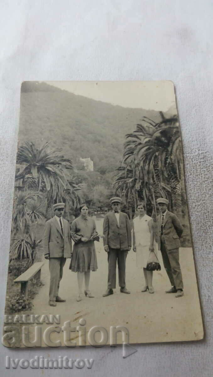 Photo Men and women next to palm trees