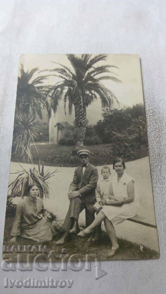 Photo Men women and a boy in front of palm trees