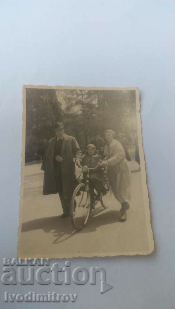 Φωτογραφία Άνδρας γυναίκα και κορίτσι με ρετρό ποδήλατο
