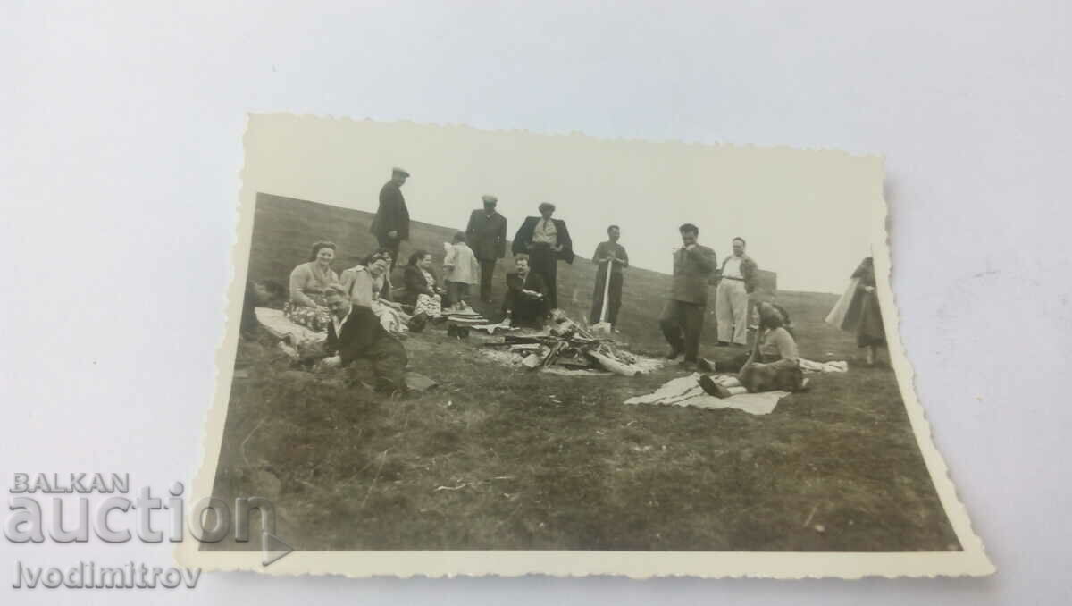 Photo Men and women on a picnic by the fire