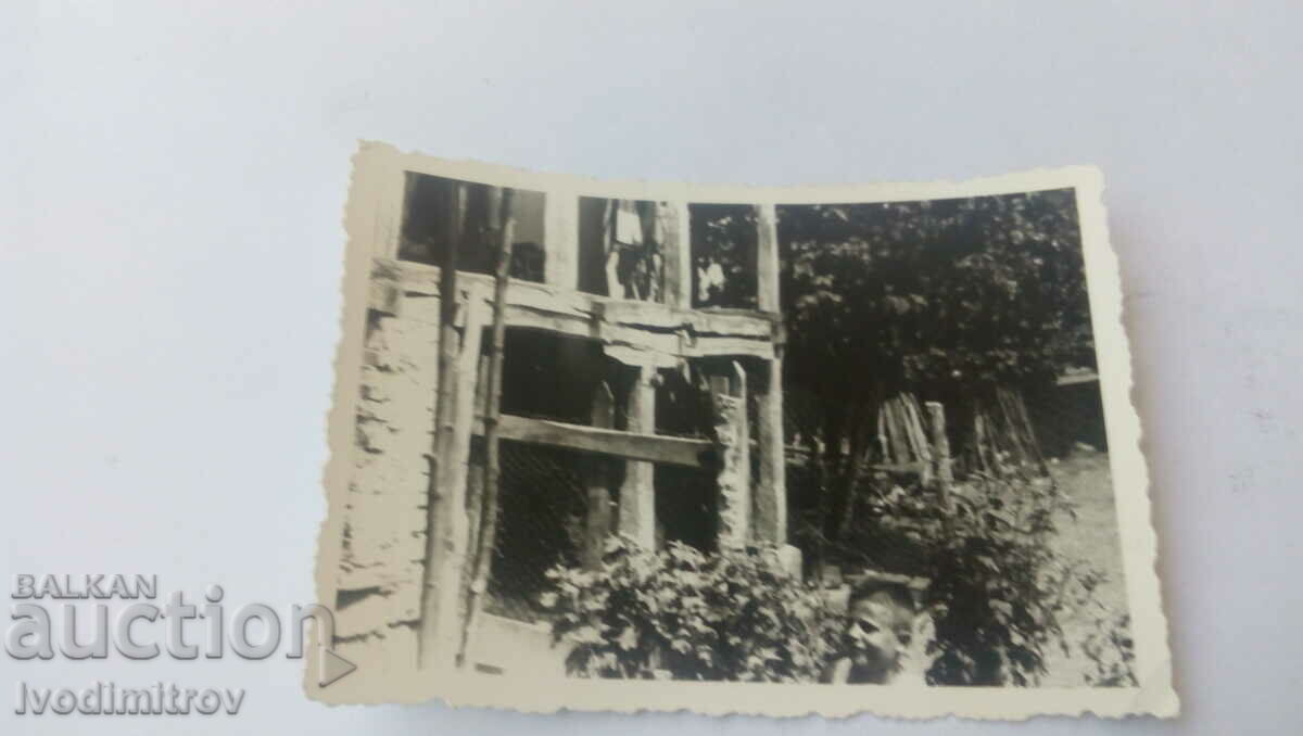 Foto Băiat lângă o casă de țară veche