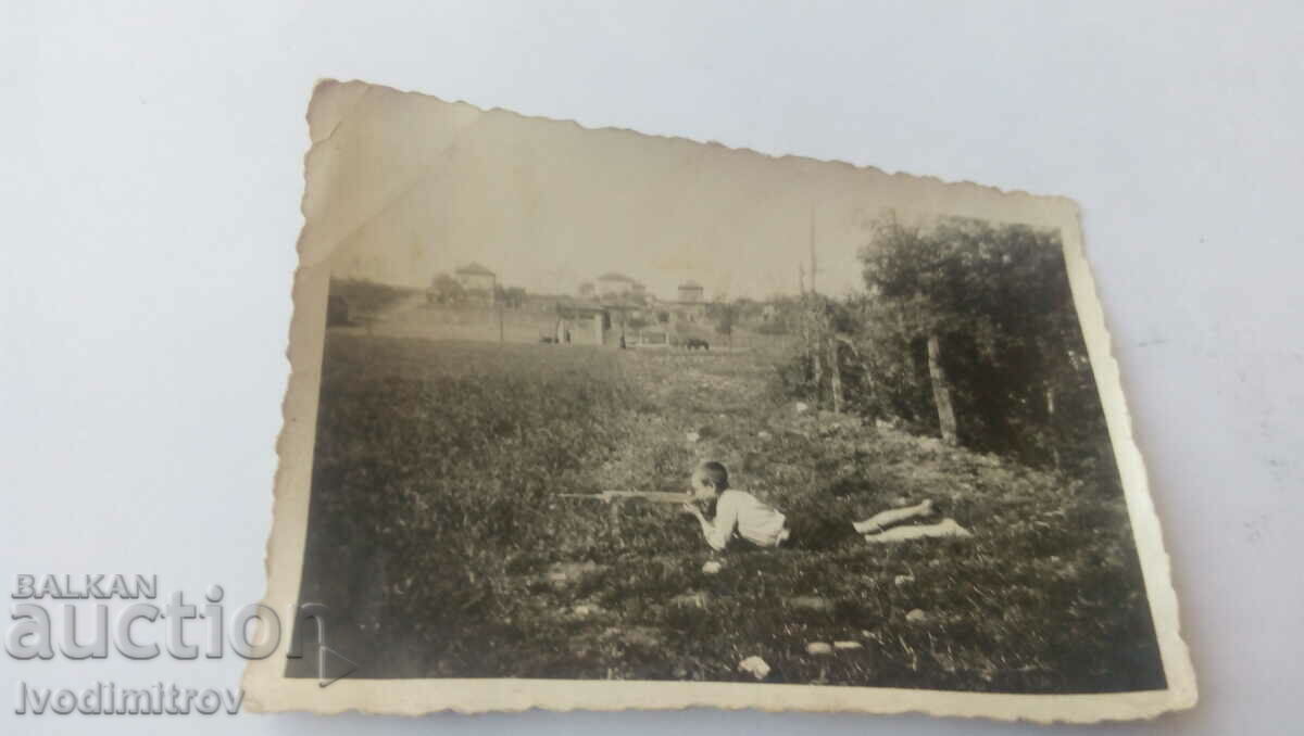 Fotografie Un băiat împușcă cu o pușcă de casă lângă sat