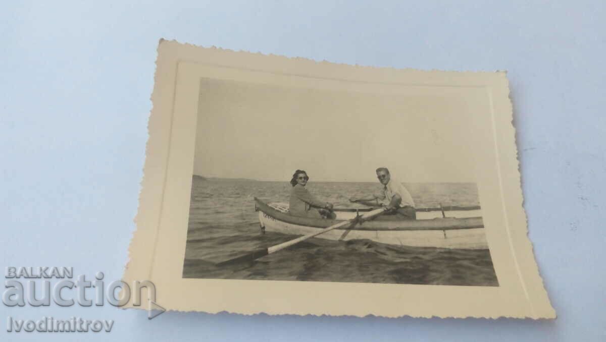 Photo Man and woman with a boat in the sea