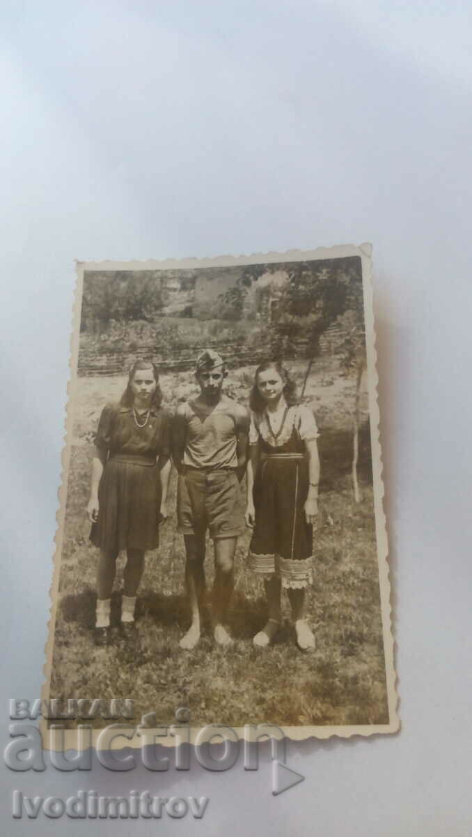 Φωτογραφία Στρατιώτης και δύο νεαρά κορίτσια στην αυλή