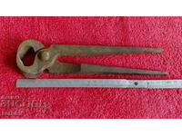Old forged massive metal pliers serpentine master