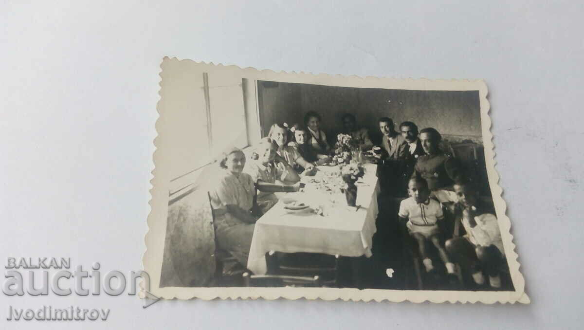 Photo Men women and children at the table 1942