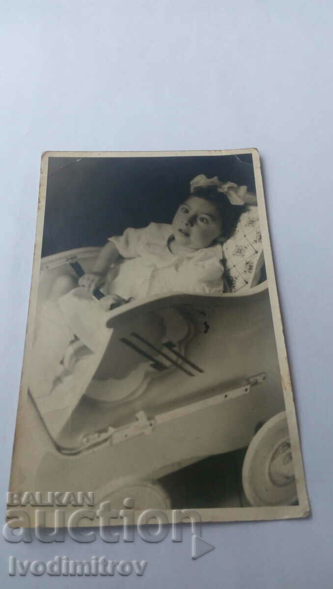 Photo of a girl in a retro stroller