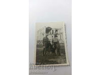Photo Sofia Two men and three children in front of a dilapidated building