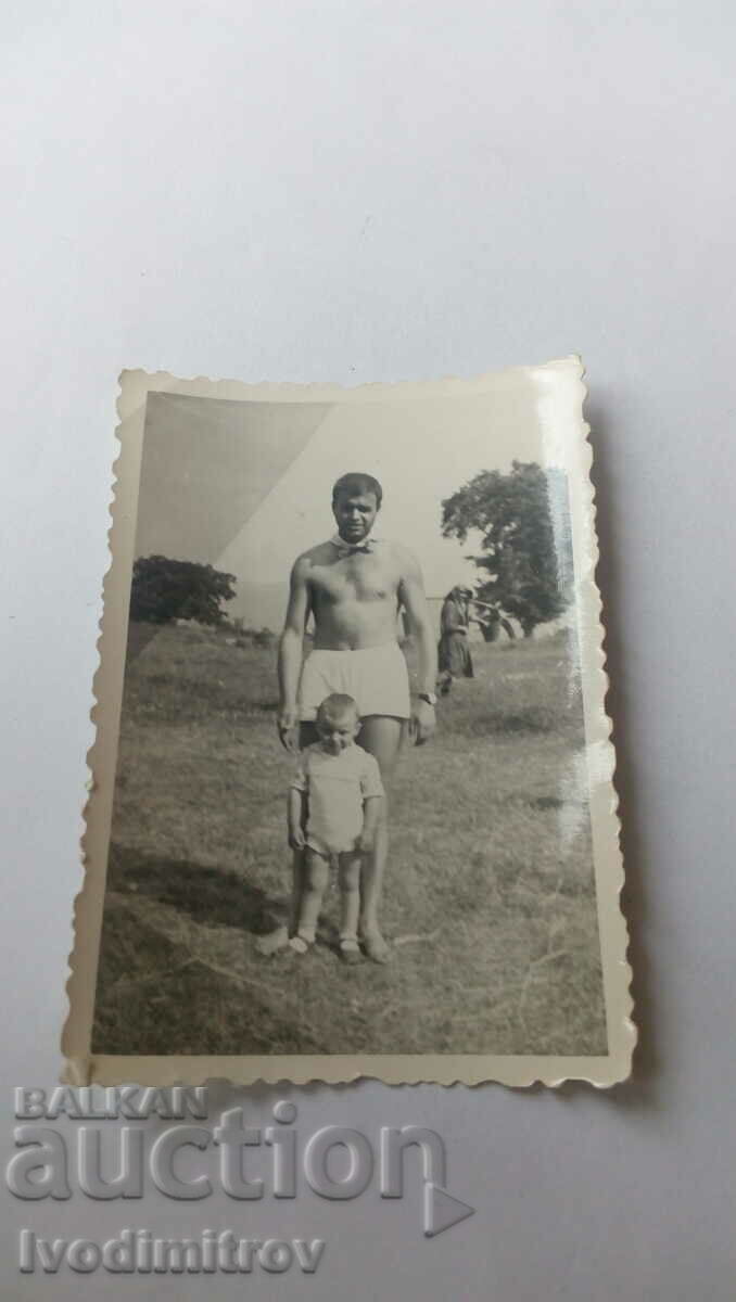 Photo of a man in shorts and a little boy