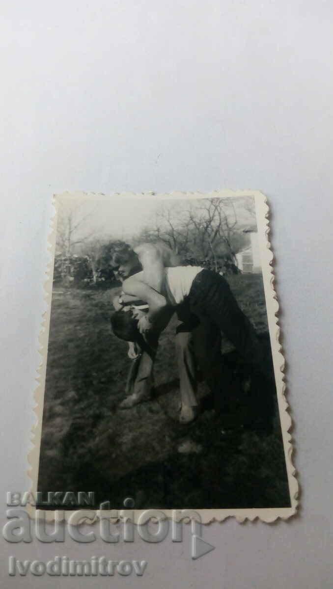 Photo of a man and a boy in a fight on the lawn