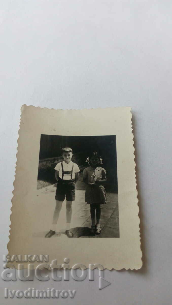 Φωτογραφία ενός αγοριού και ενός κοριτσιού στο πεζοδρόμιο